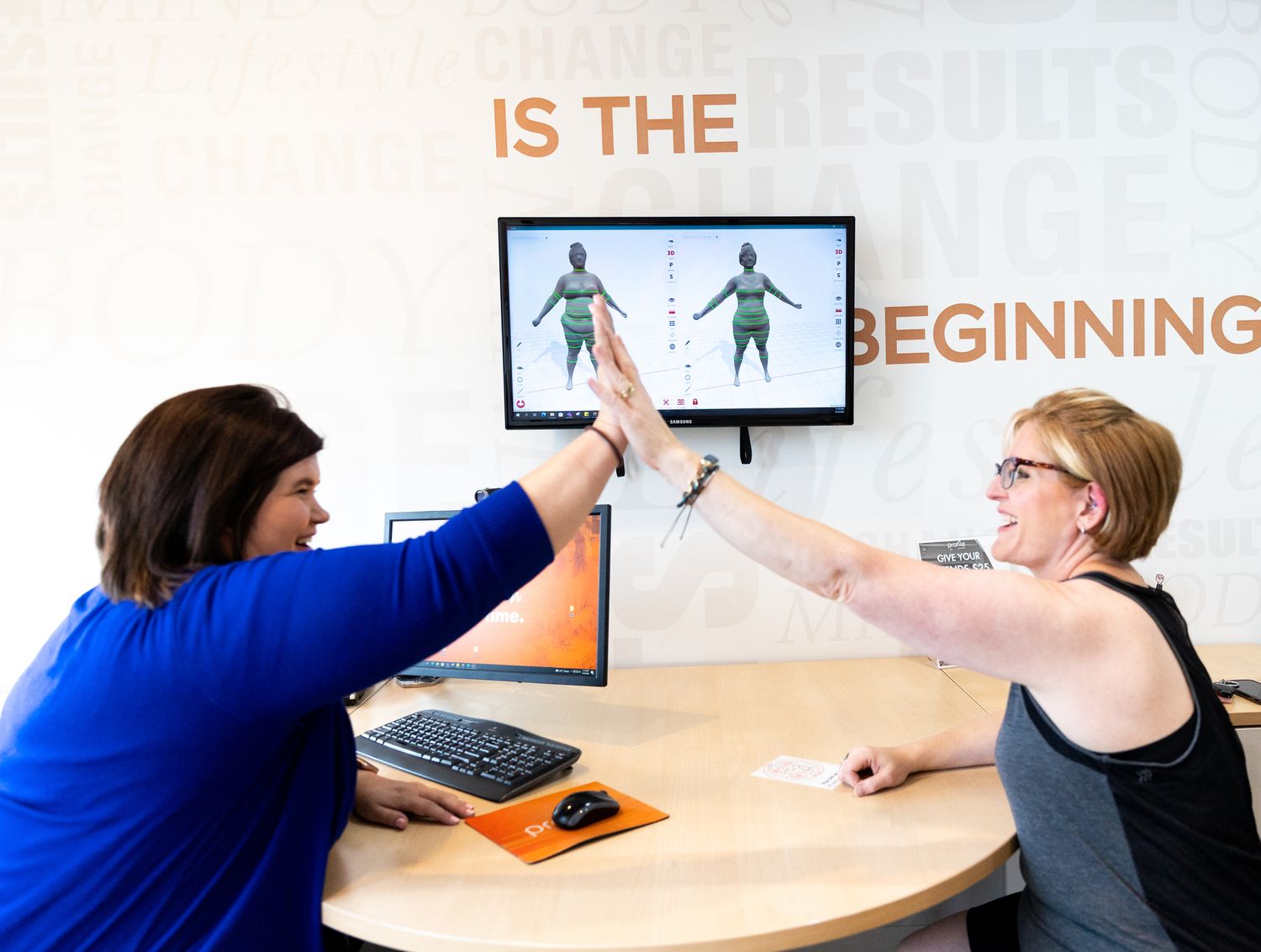 Business professionals collaborating and engaging in discussion around a curved desk in a modern office setting.