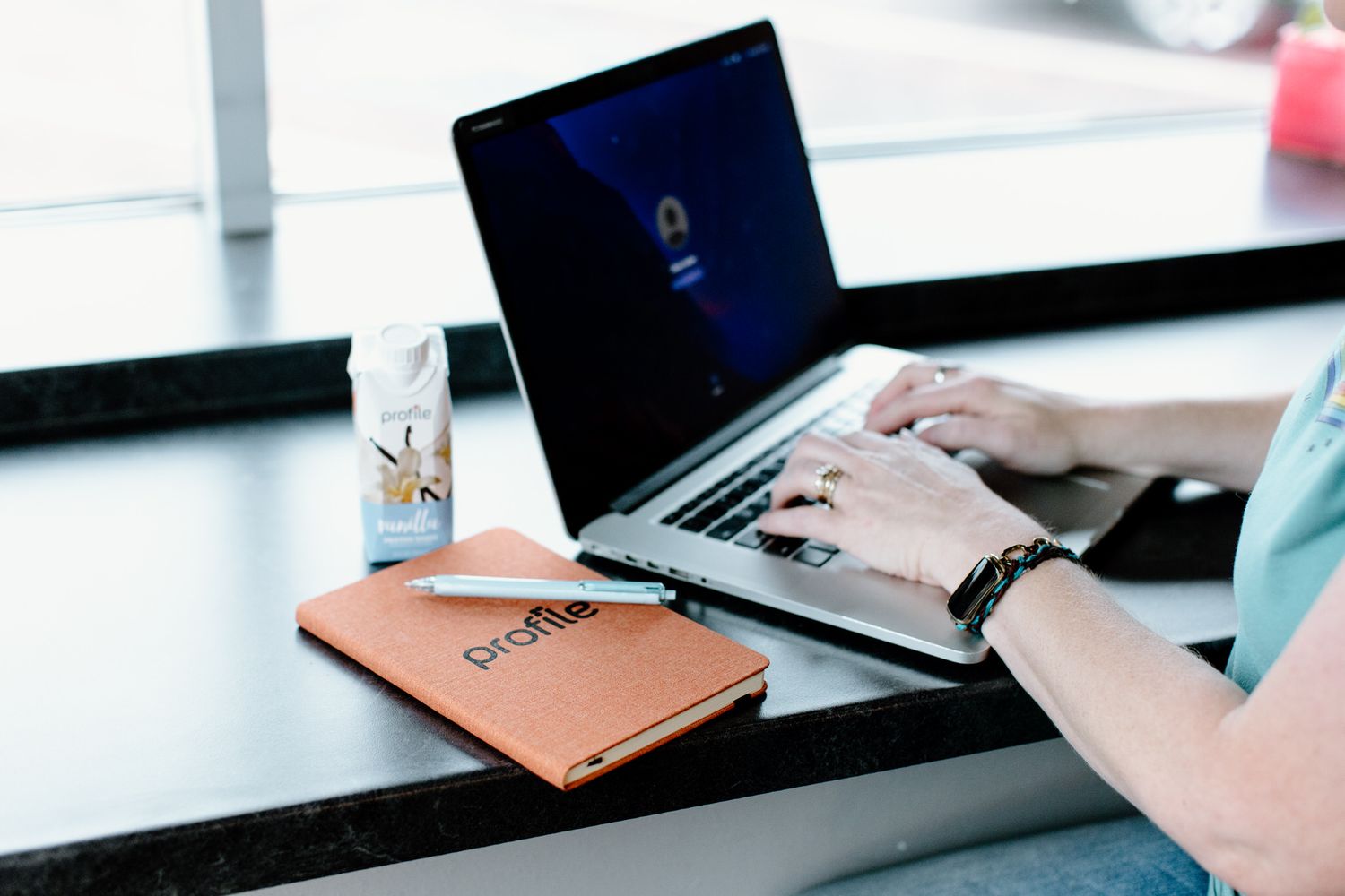 Person working on laptop computer in modern office setting.