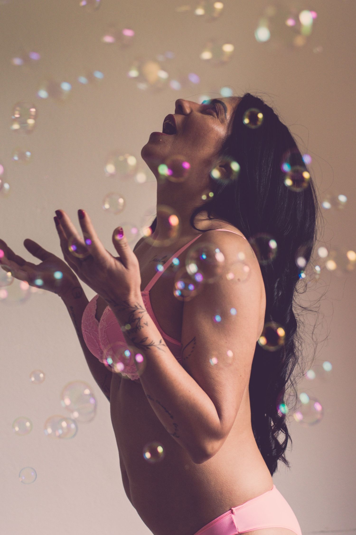 A silhouetted figure poses with colorful bubbles or sparkles floating in the air.