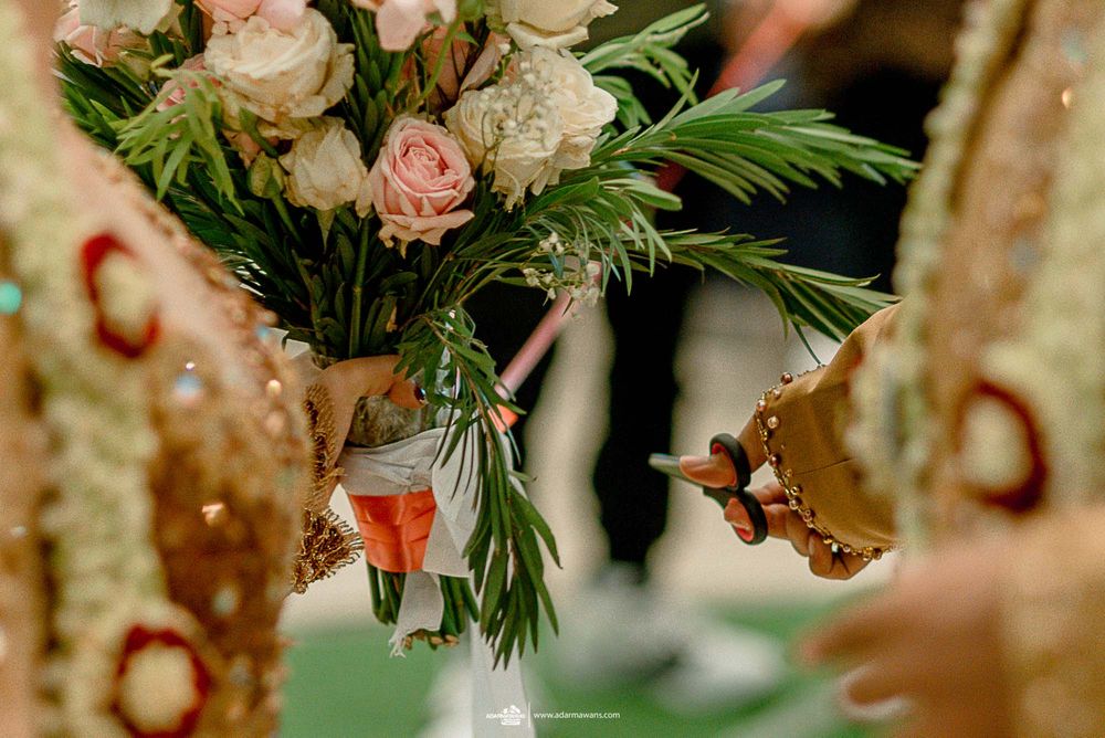 Close-up of pink roses and greenery in an elegant wedding floral arrangement.
