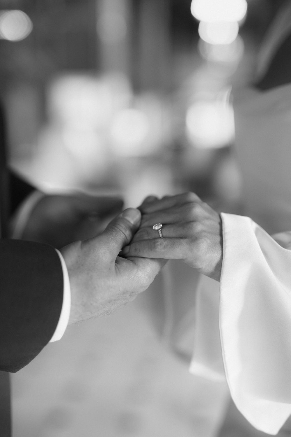 Close-up sequence of hands holding in elegant white formal wear.