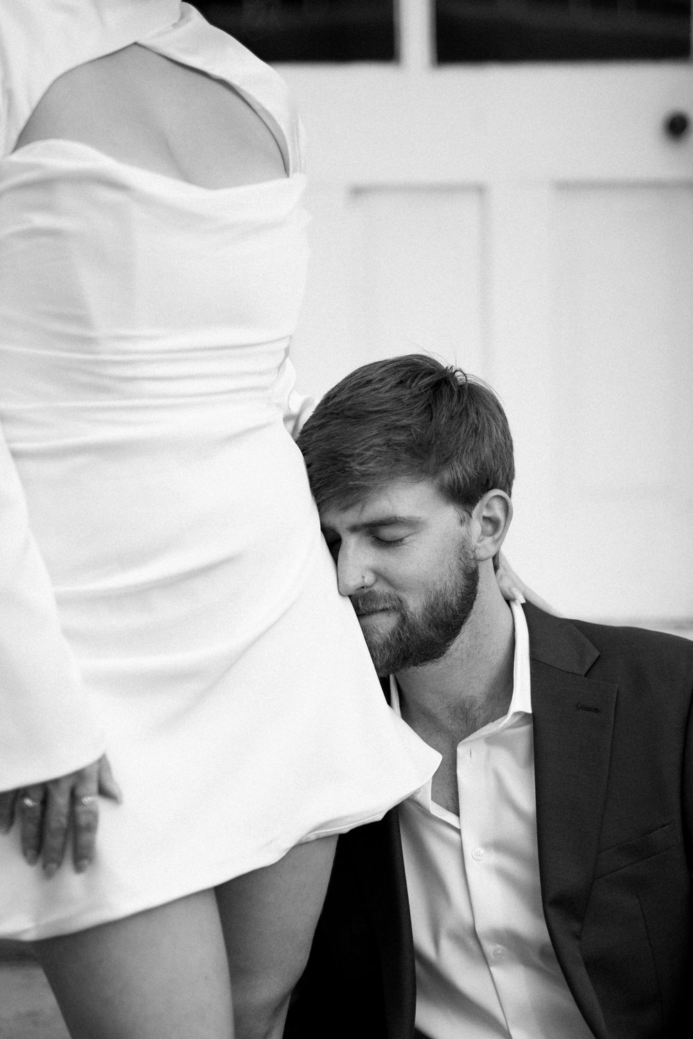 Intimate black and white close-up shot of a couple sharing a tender moment on steps.