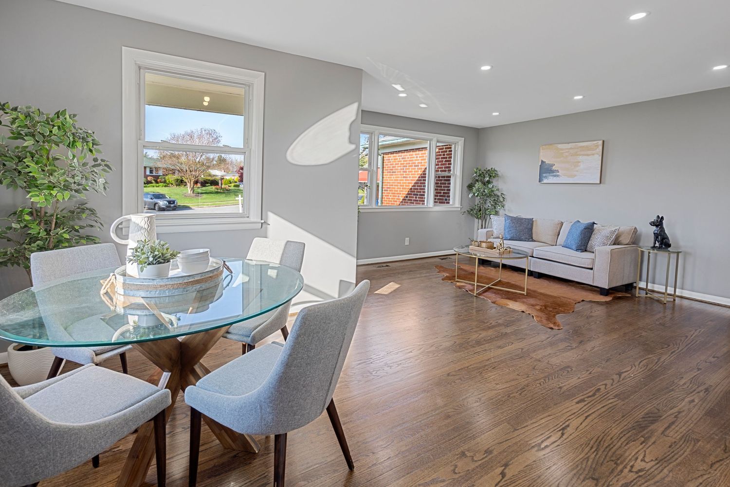 Bright open concept living and dining area with modern furniture and hardwood floors.