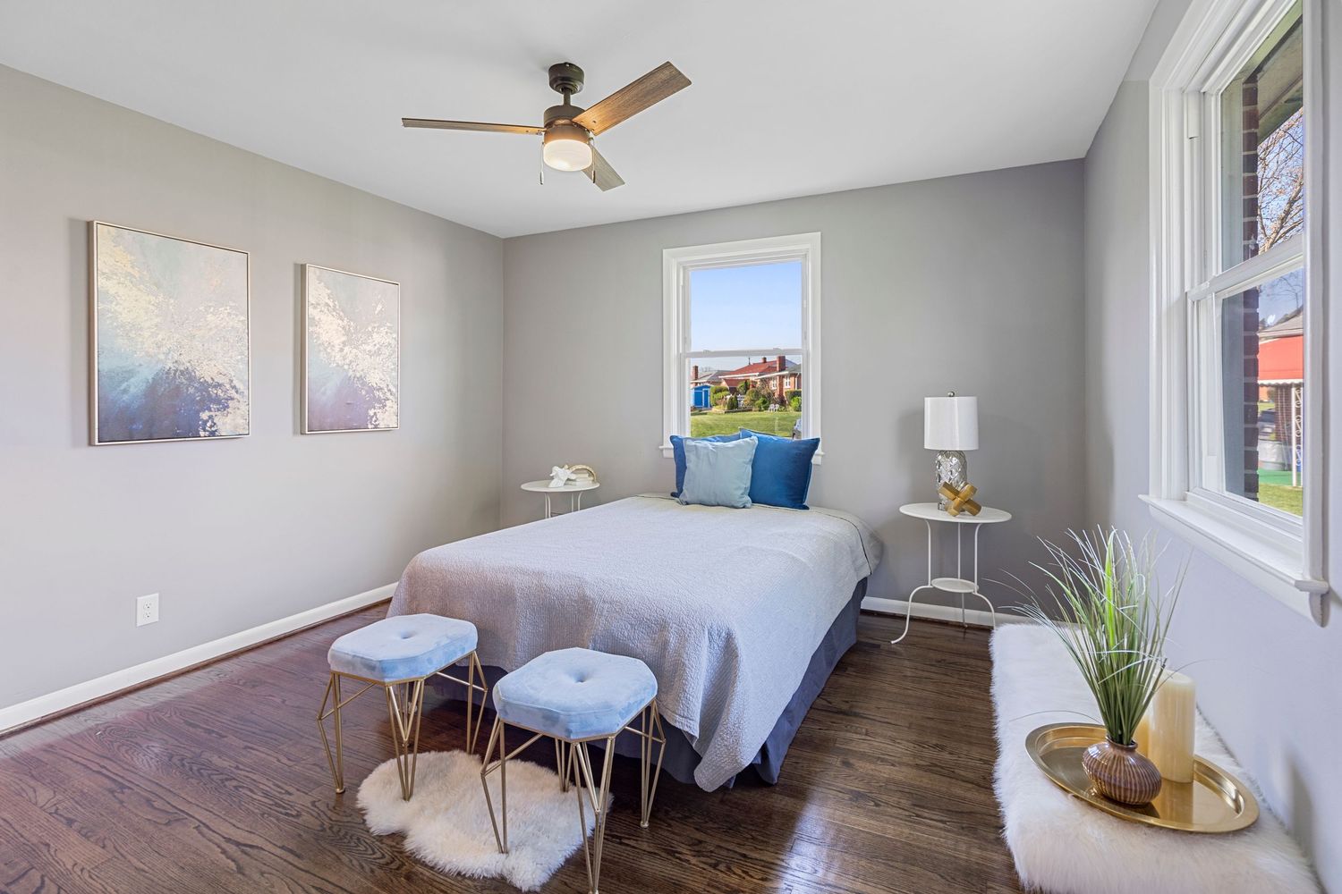 Contemporary bedroom with blue accents, gray walls, and decorative artwork.