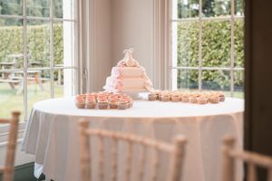 Elegant wedding reception venue with white chairs and natural light streaming through large windows.
