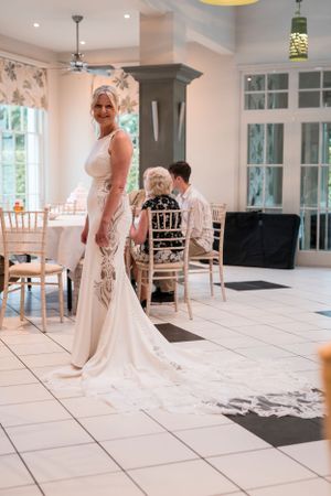 Wedding venue interior with white tile floors and elegant chiavari chairs set up for reception.