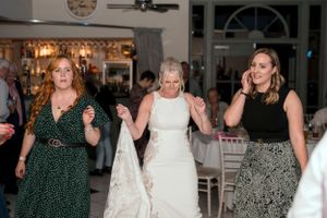 Wedding guests dancing and celebrating on the dance floor at a reception.