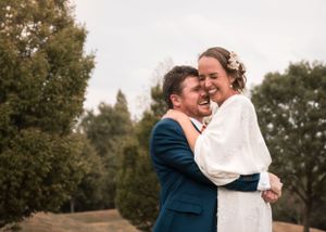 Couple sharing intimate embrace outdoors during autumn photo session.