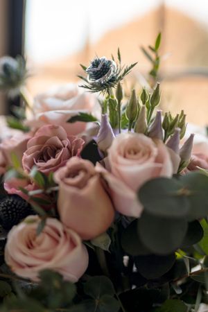 Soft pink roses and delicate flowers arranged in a romantic wedding bouquet.