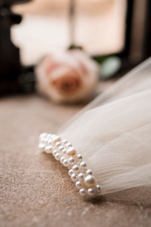 Delicate pearl details on sheer white wedding veil fabric.