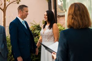 An intimate outdoor wedding ceremony moment captured in a garden setting.