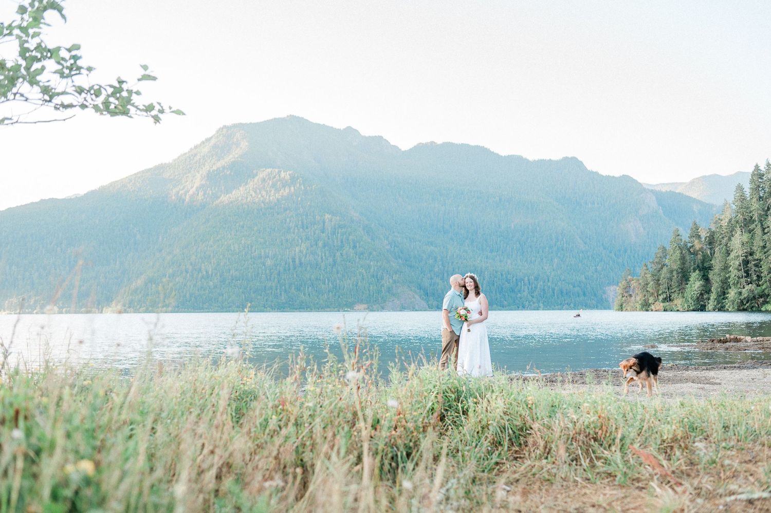 Groom kisses his bride at Lake Crescent elopement. Photo by Pine + Vow.