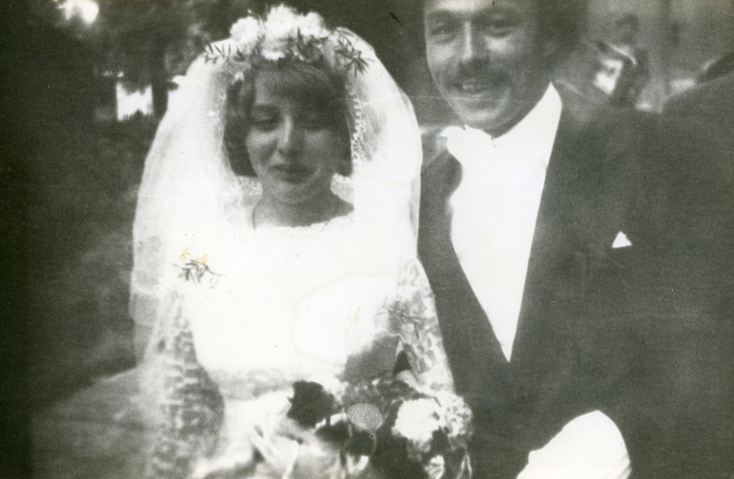 Vintage black and white wedding photograph showing a couple in traditional formal attire.