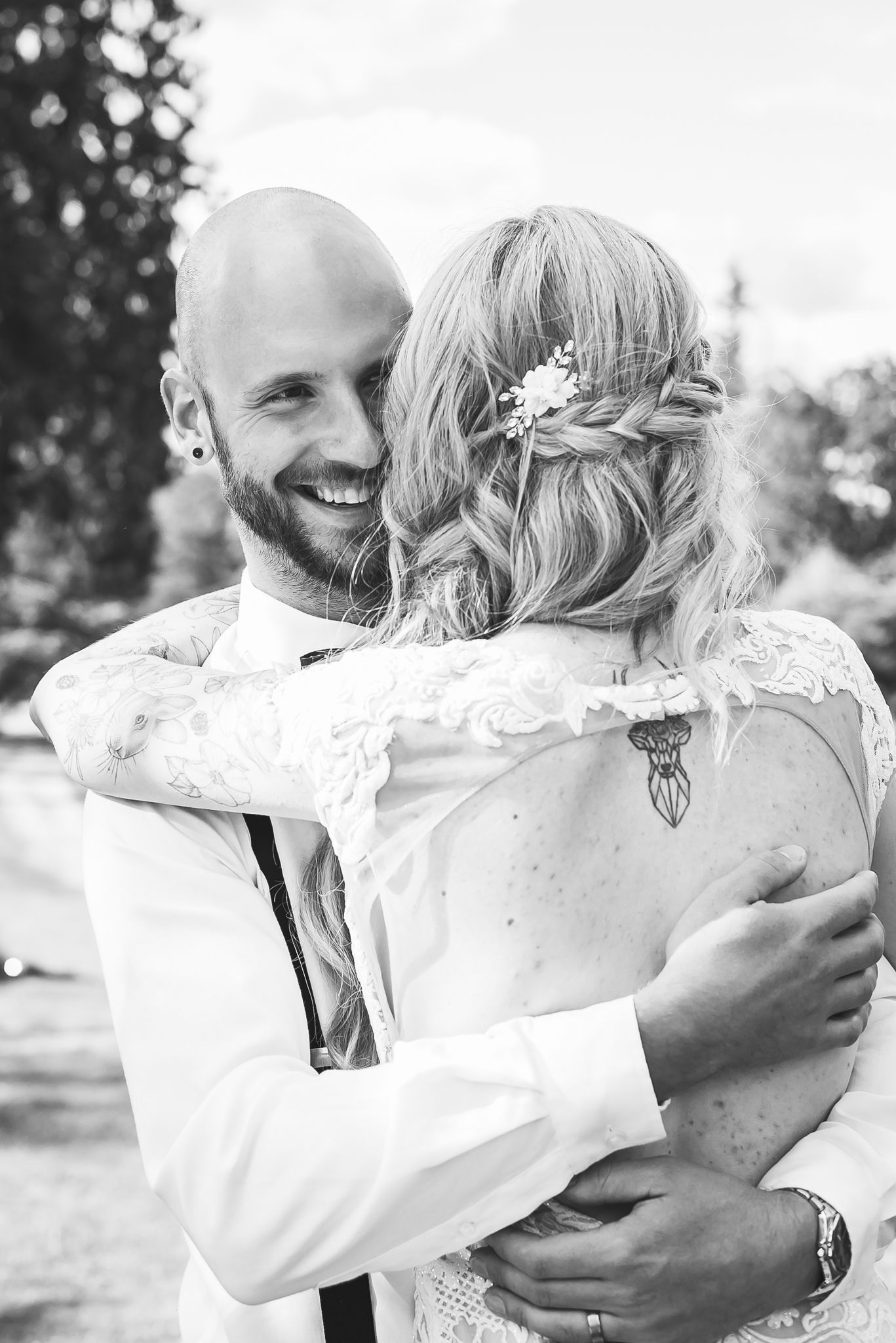 Black and white image of a groom hugging his bride while smiling. Photo taken in Hope, B.C. by Kari Mills Photography.