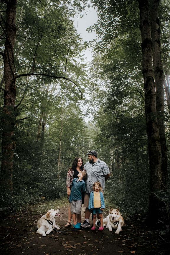 Family portrait of 4 and their two dogs in a forest in Ottawa, ON
