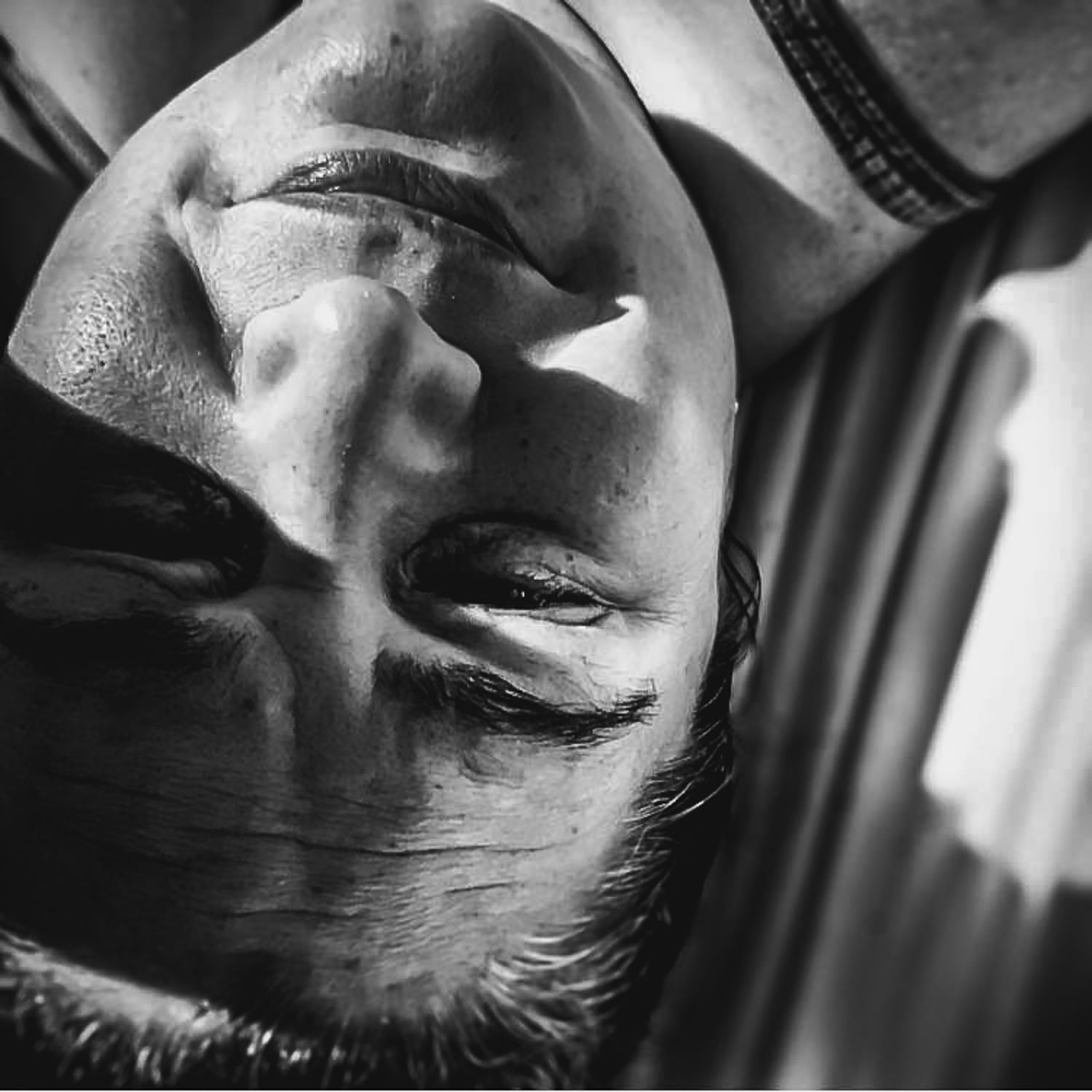 BW selfie of a middle aged woman's face as she lays in a hammock in the sun.