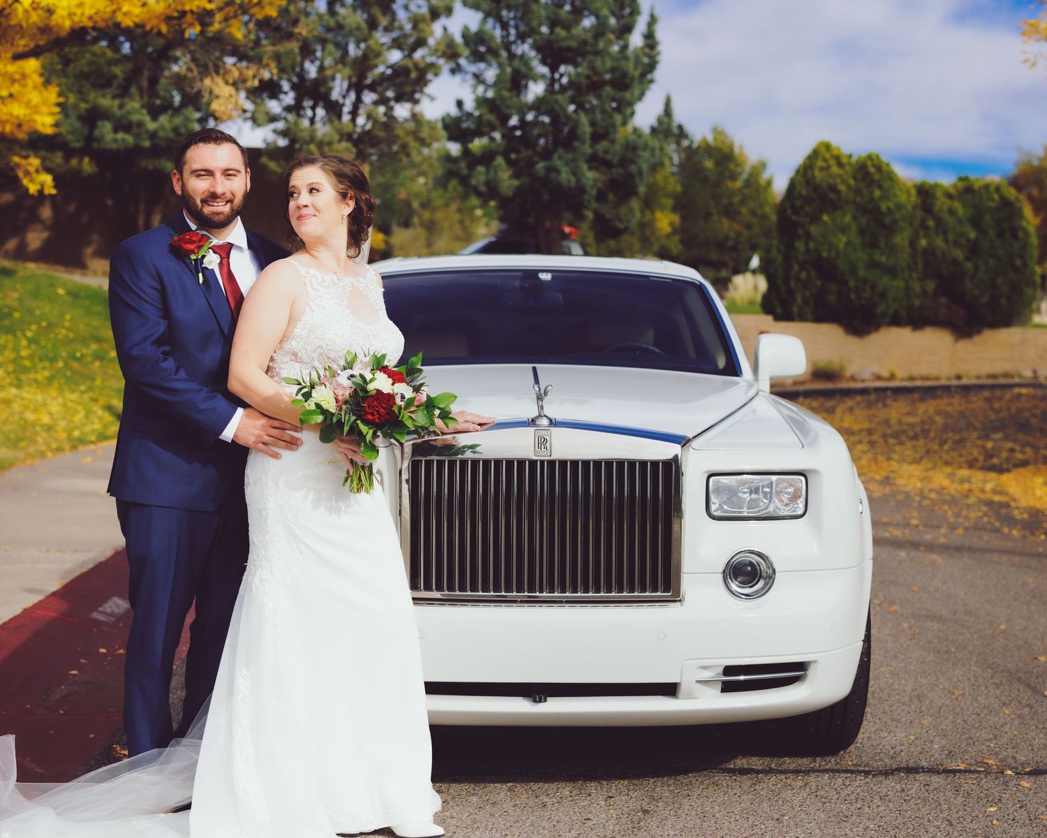 Wedding couple standing in front of Rolls Royce