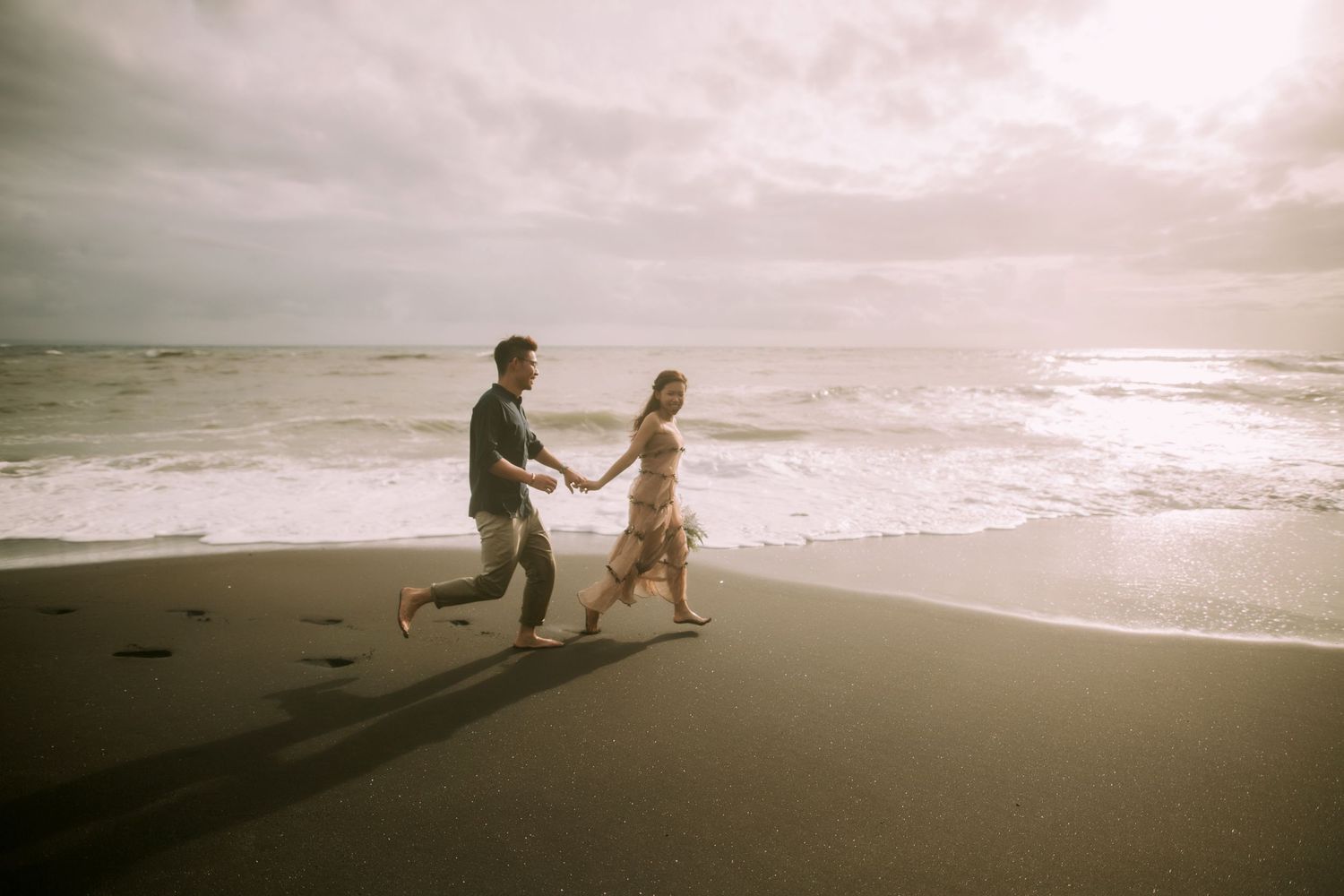 A romantic beach proposal scene unfolds at sunset with waves crashing in the background.
