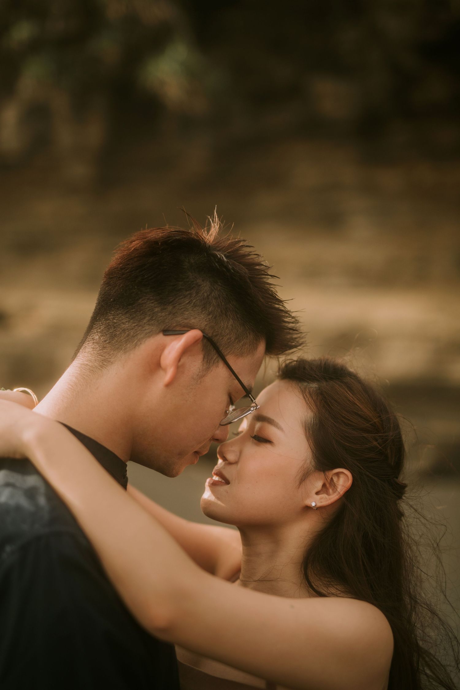 Close-up of a loving embrace on a dramatic coastal landscape.