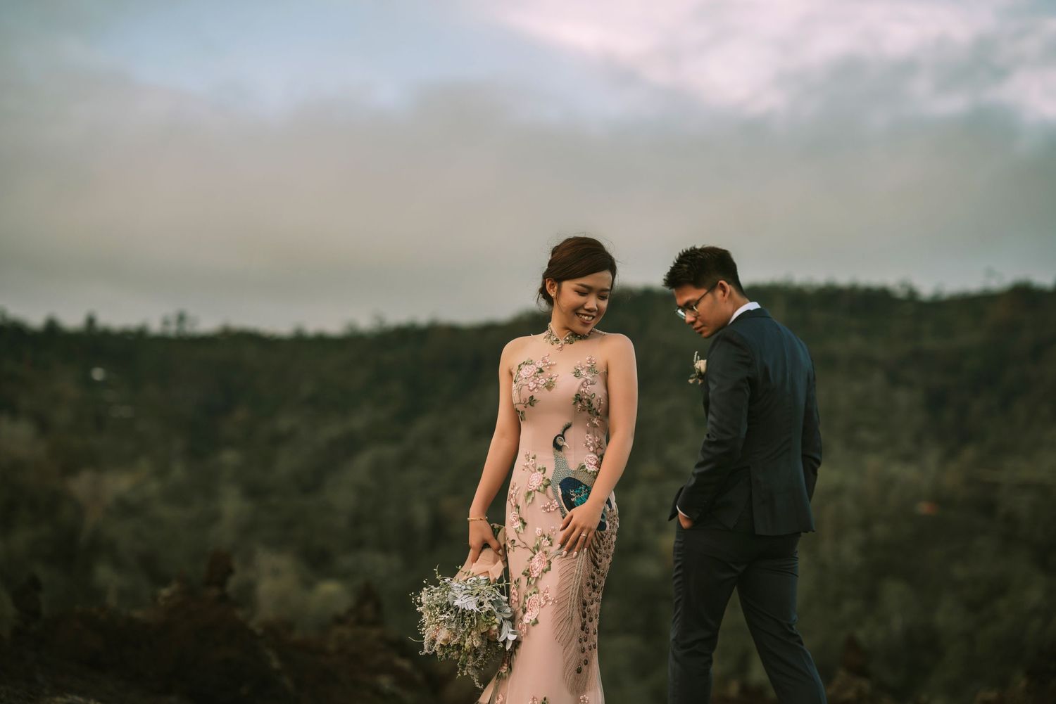 Couple shares candid moment on mountainside in formal attire.