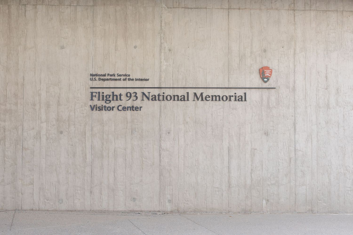 A sign for the Flight 93 National Memorial Visitor Center on a concrete wall.