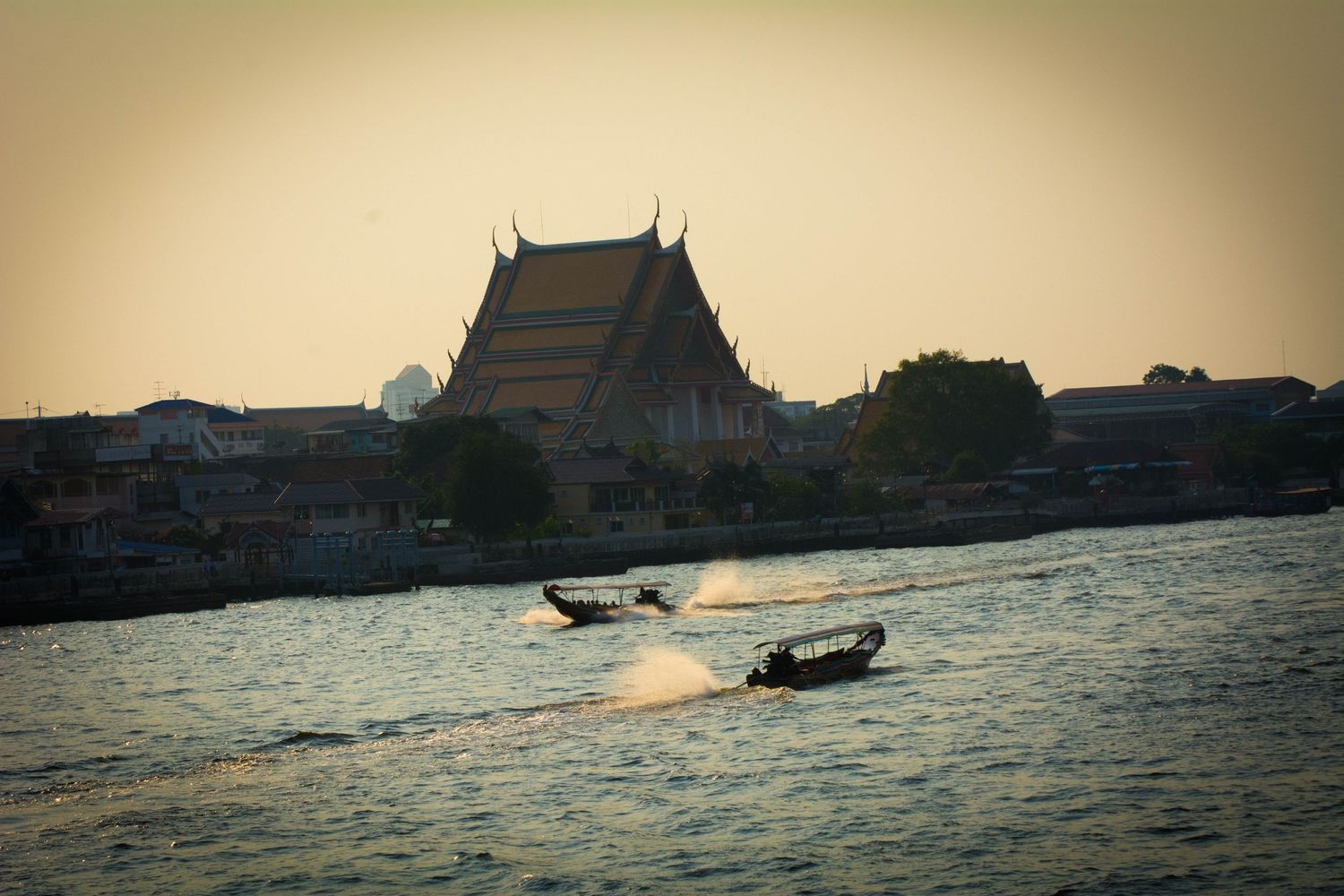 Long-tail boats crossing on the Chao Phraya river in Bangkok Thailand
