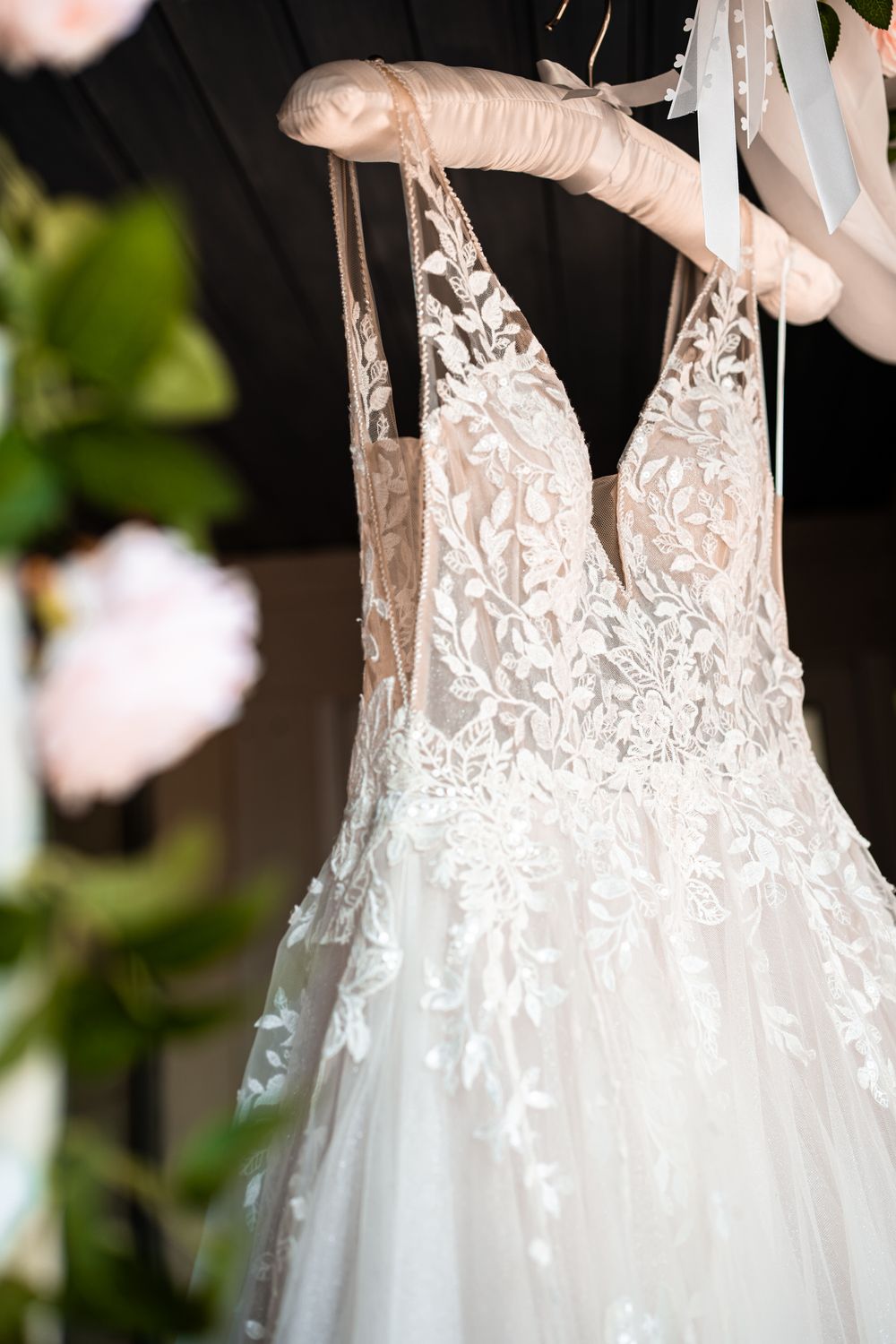 Close-up detail of delicate lace bodice on white wedding dress.
