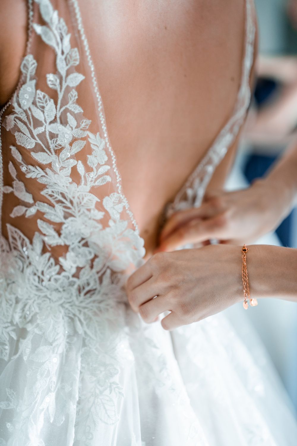 Close-up detail of delicate floral lace on a white wedding gown bodice.