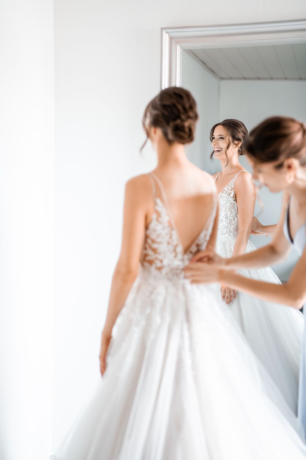 Elegant wedding dress reflection in mirror during final fitting.