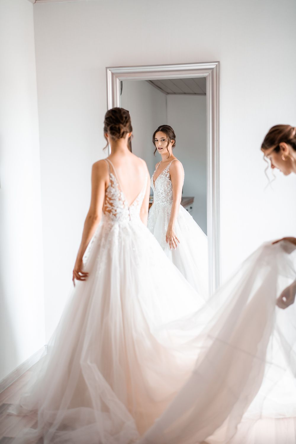 Wedding dress with flowing train captured in mirror reflection.