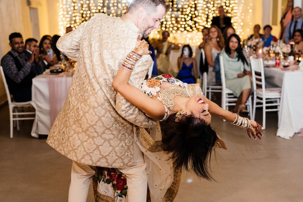 groom twirling his bride on the dancefloor in traditional hindu wedding attire