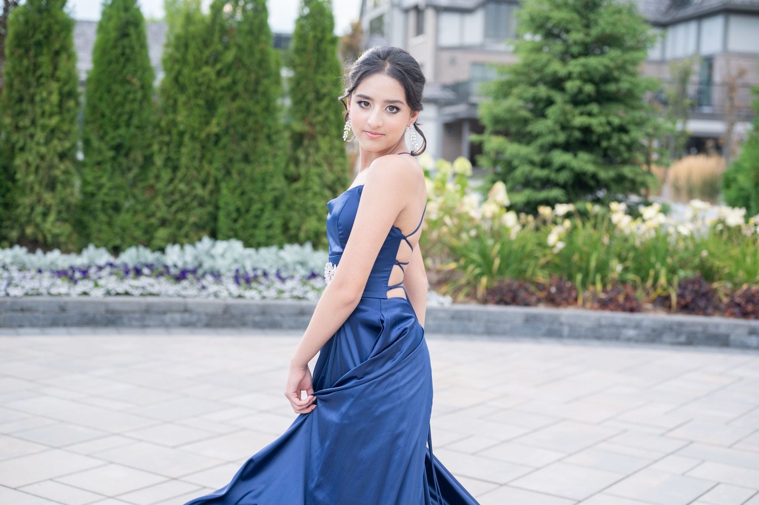 Flowing navy blue formal gown photographed on outdoor stone patio.
