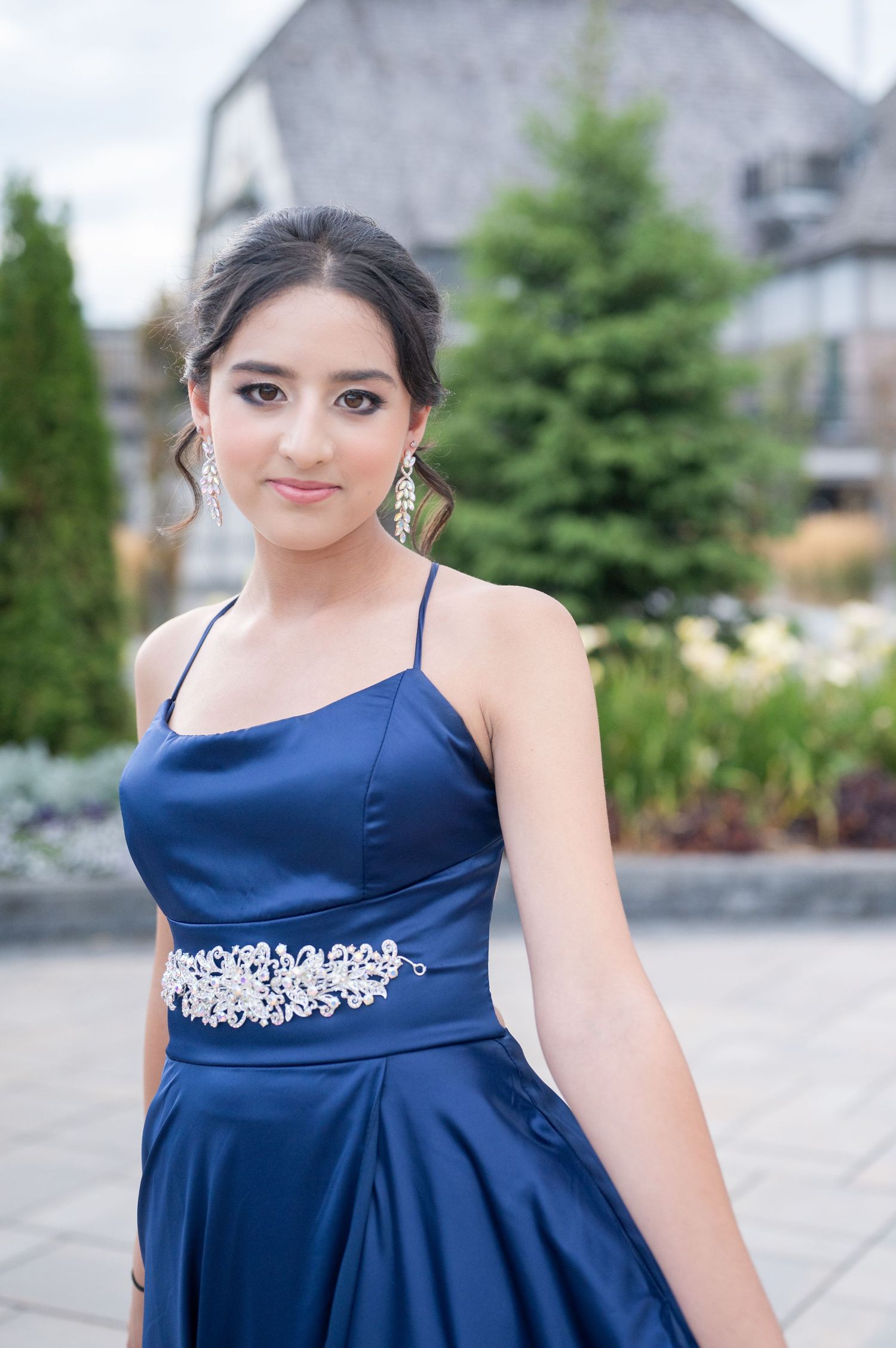Navy blue formal gown with crystal embellished waistband photographed outdoors.
