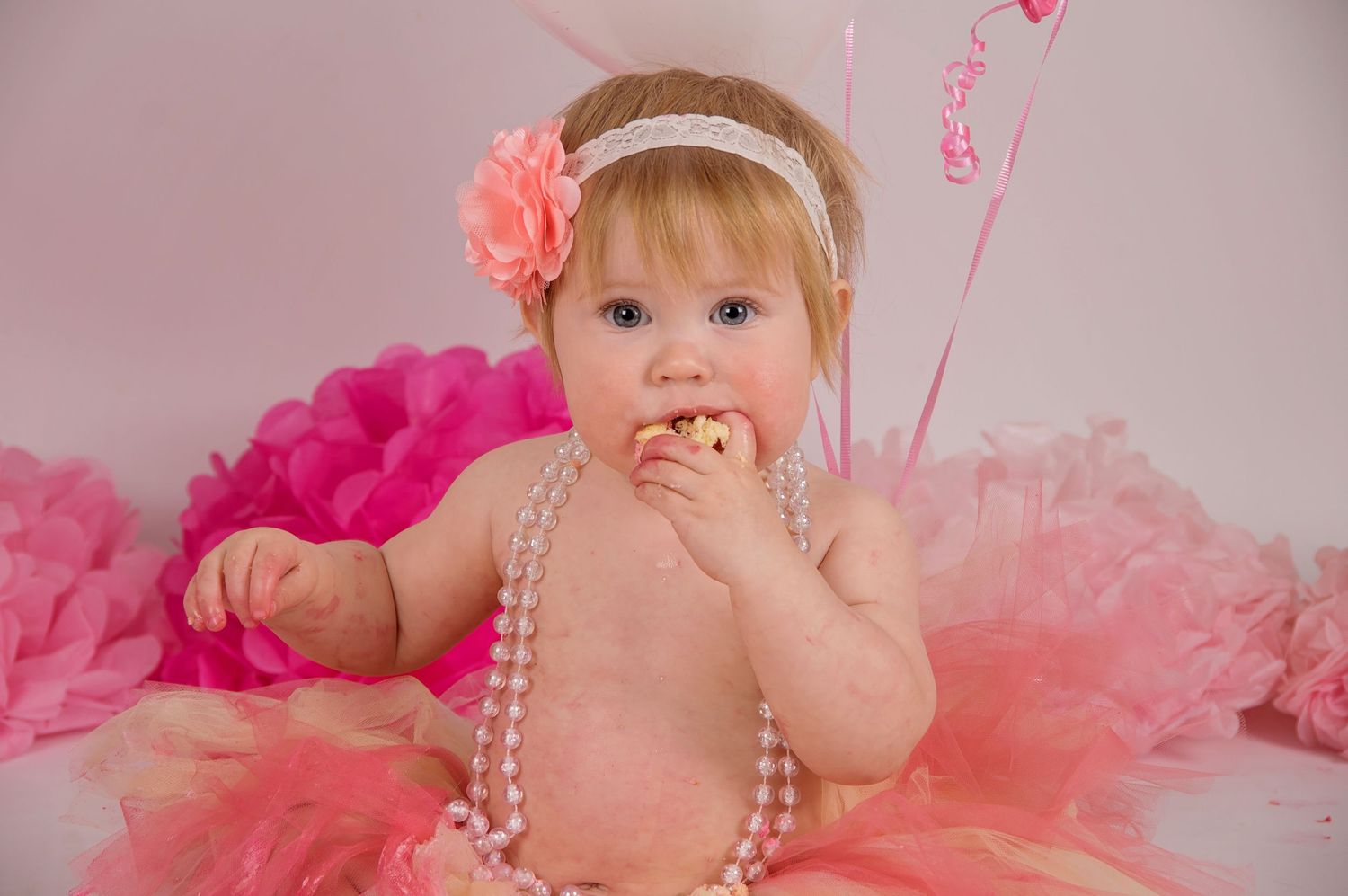 baby girl eating cake in pink tutu
