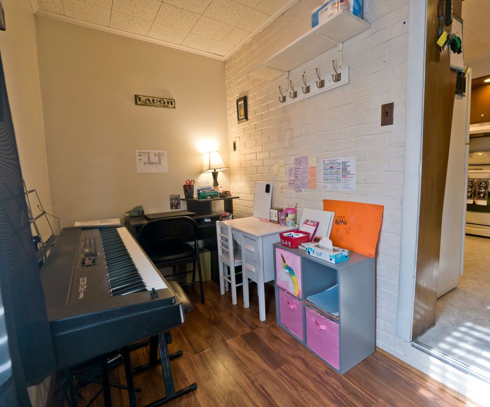 Music room with digital piano, white brick wall, and colorful storage cubes.