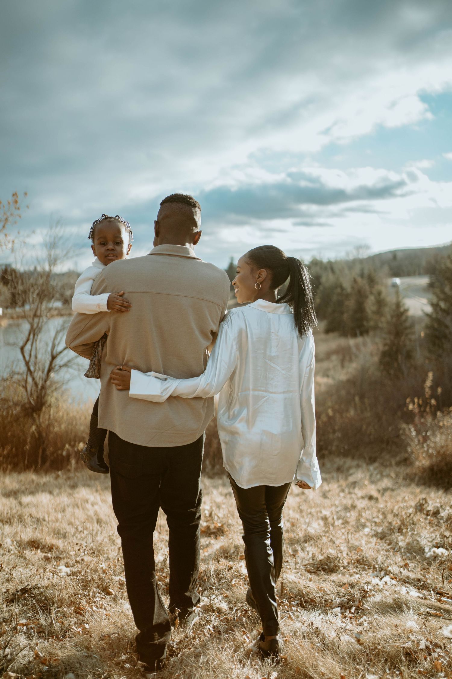A family enjoys a scenic overlook together on a cloudy autumn day in nature.
