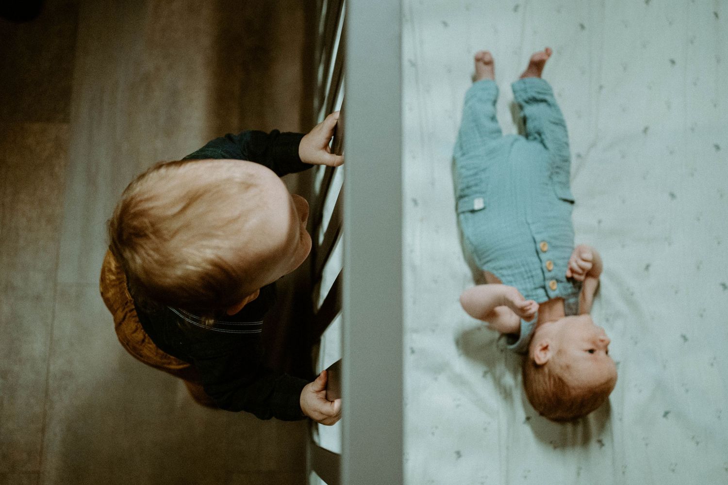 Overhead view of a baby lying down in blue clothing.