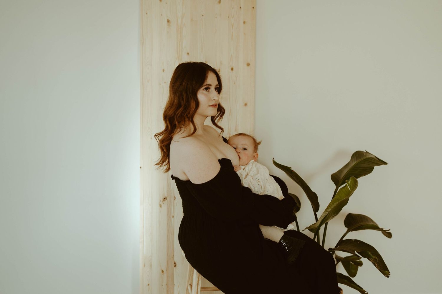 Artistic portrait by wooden panel shows tender moment between parent and child.