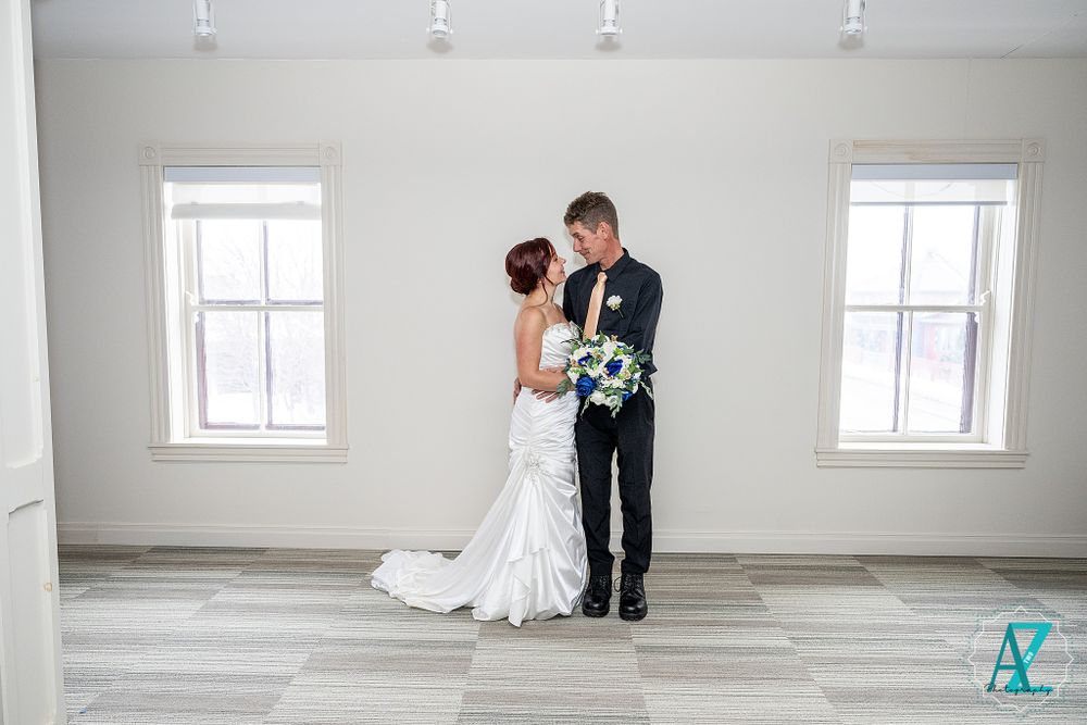 Elegant wedding couple shares an intimate moment in a bright white room.
