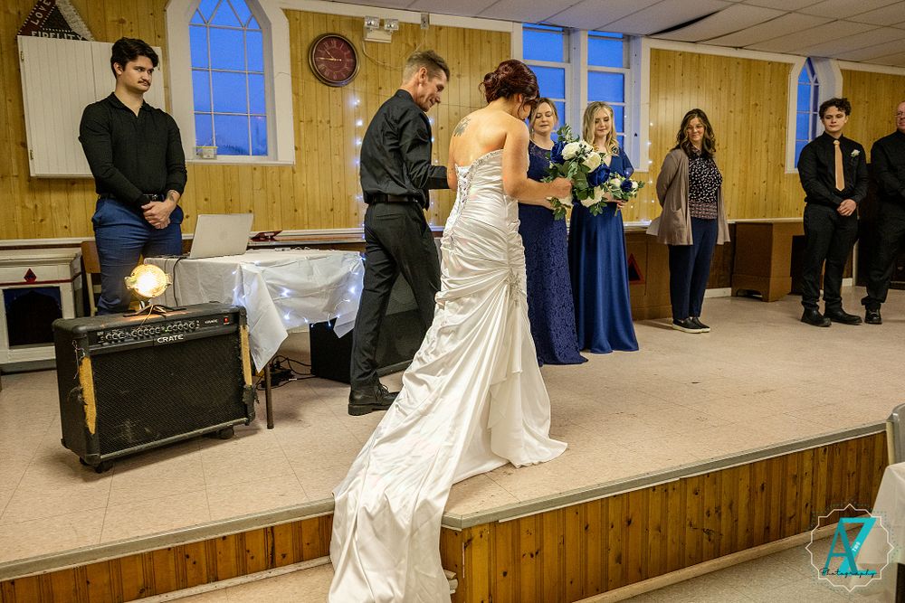 Wedding celebration in a wood-paneled venue with traditional decor and arched windows.