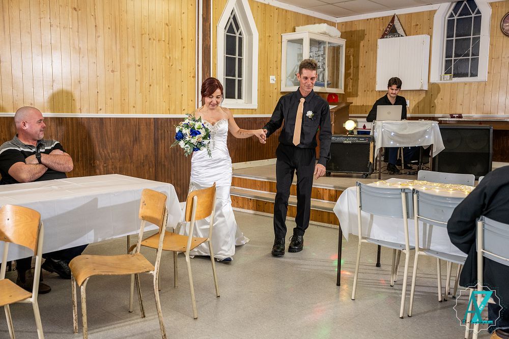 Dancers perform in a rustic church hall with wooden walls and arched windows.
