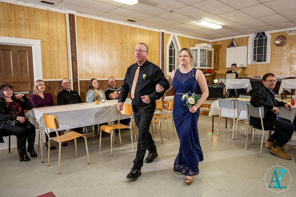 Formal dancers perform in a church reception hall with wood paneling and gothic windows.