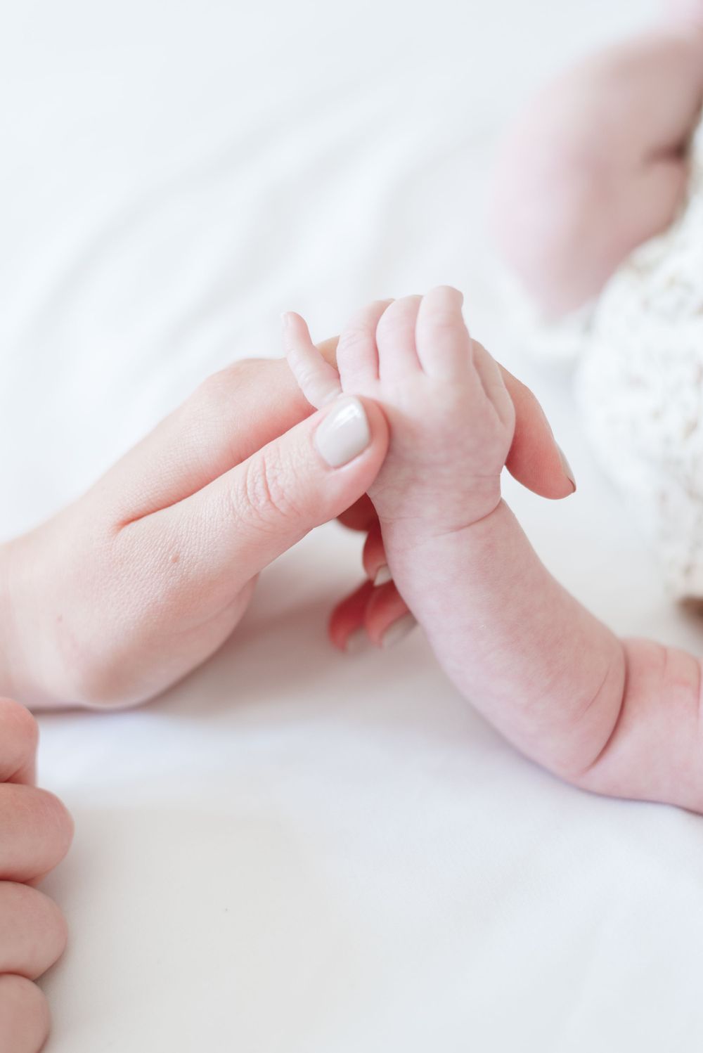 Close-up of newborn baby's fingers as his mother holds his hand during a lifestyle photoshoot in their Toronto home, by Jess GC Photogry