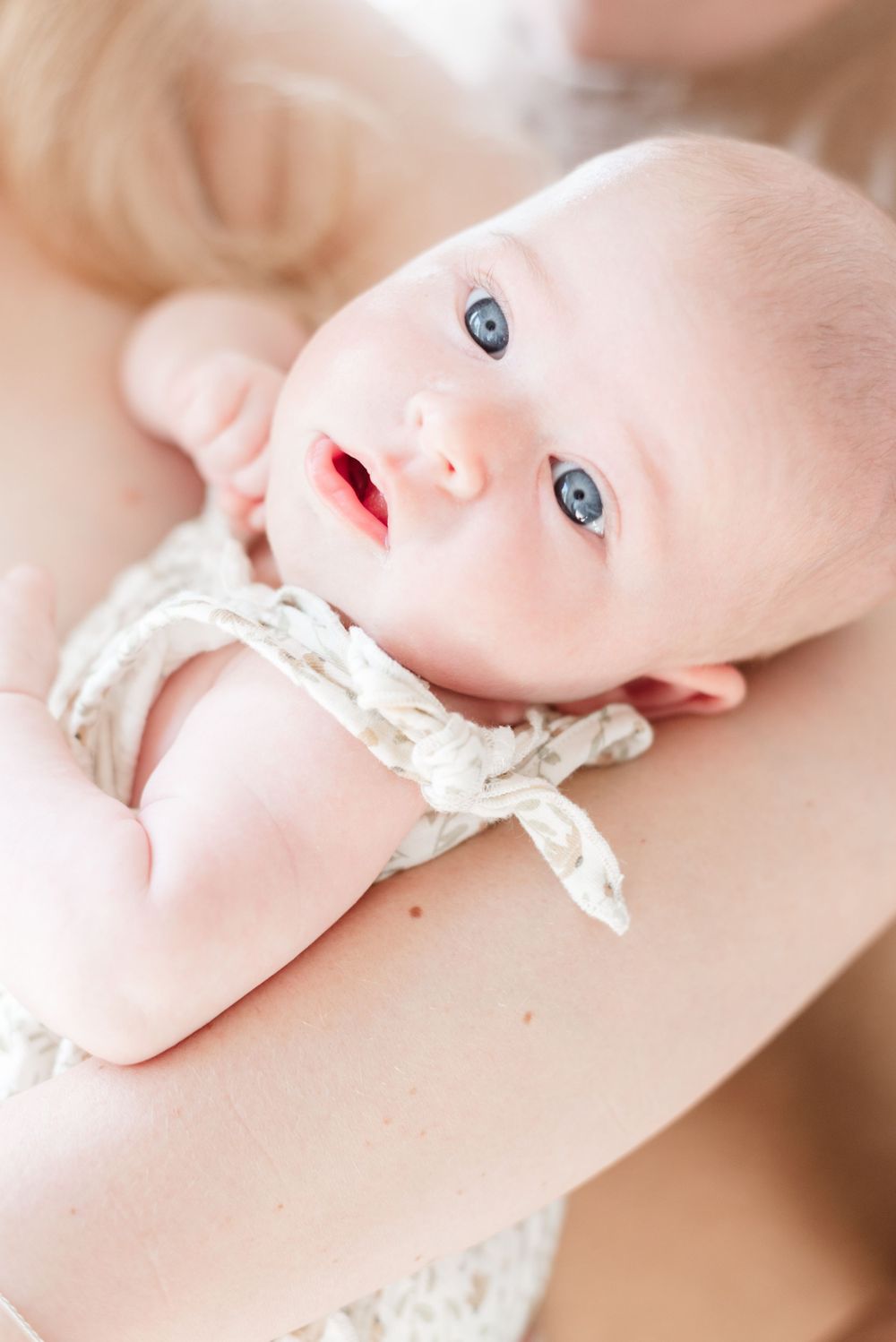 Newborn baby girl cradled in mother's arms during an in-home lifestyle photoshoot in Toronto, captured by Jess GC Photography.