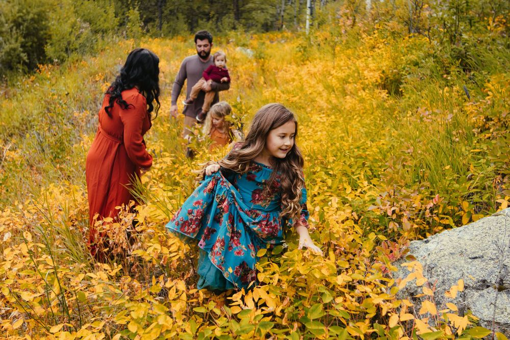 People enjoying a bright autumn day amid golden yellow foliage on a mountain trail.