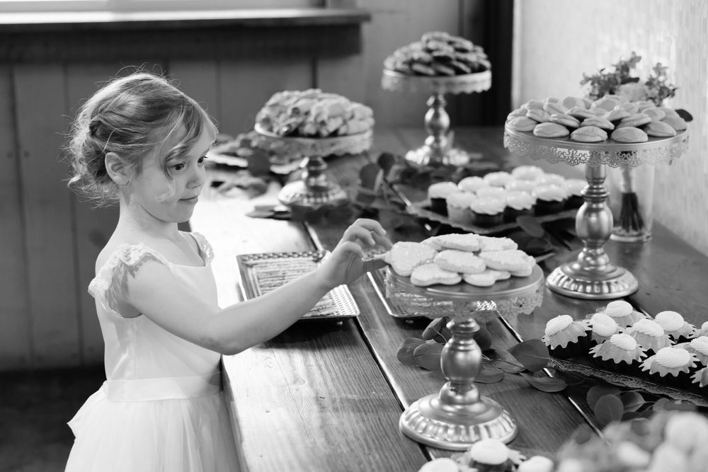 Flower girls sneaks cookie during wedding reception at Jorgensen Farms in Westerville, Ohio.
