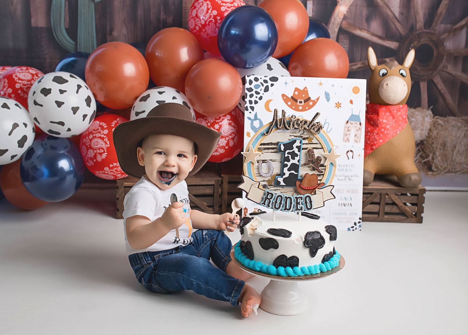 Western themed birthday setup with cowboy cake and orange balloon decorations.