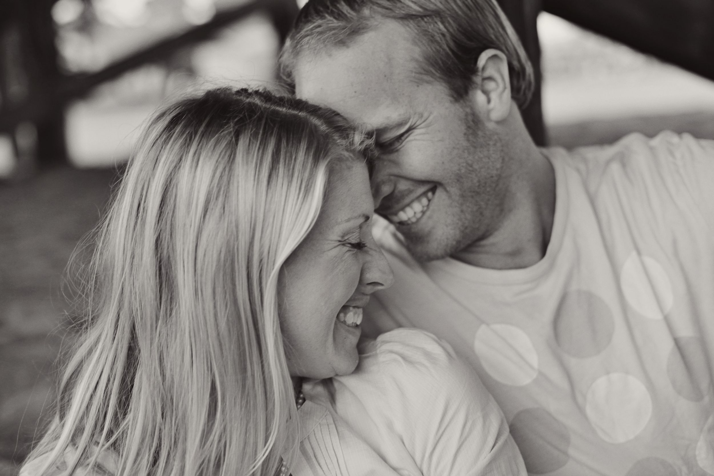 Intimate black and white photo of couple sharing tender moment outdoors.