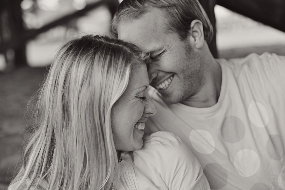Intimate black and white photo of couple sharing tender moment outdoors.