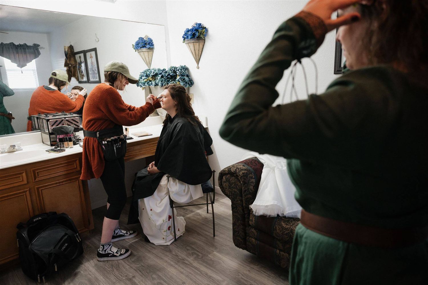 Makeup artist working behind the scenes in a dressing room.